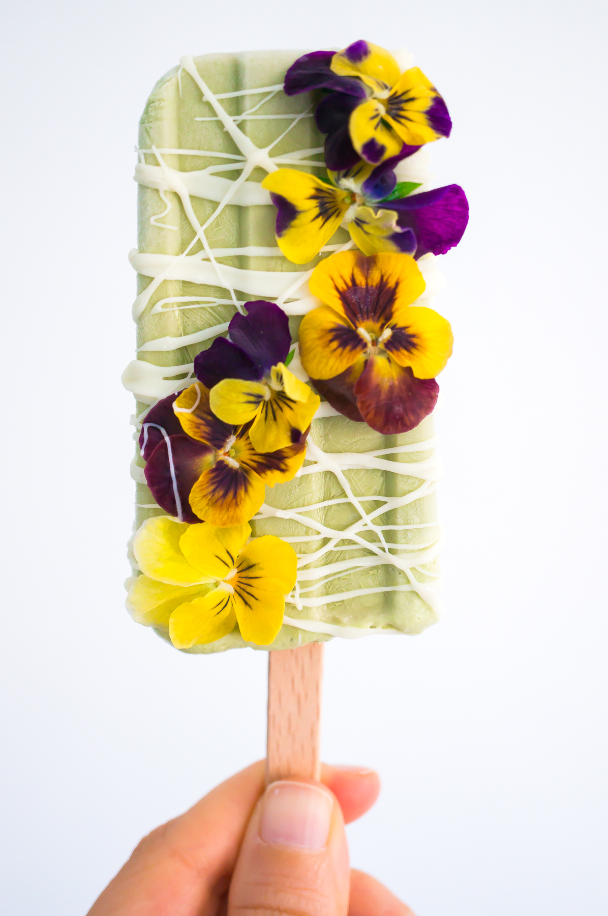 Basil popsicle with white chocolate and edible flowers